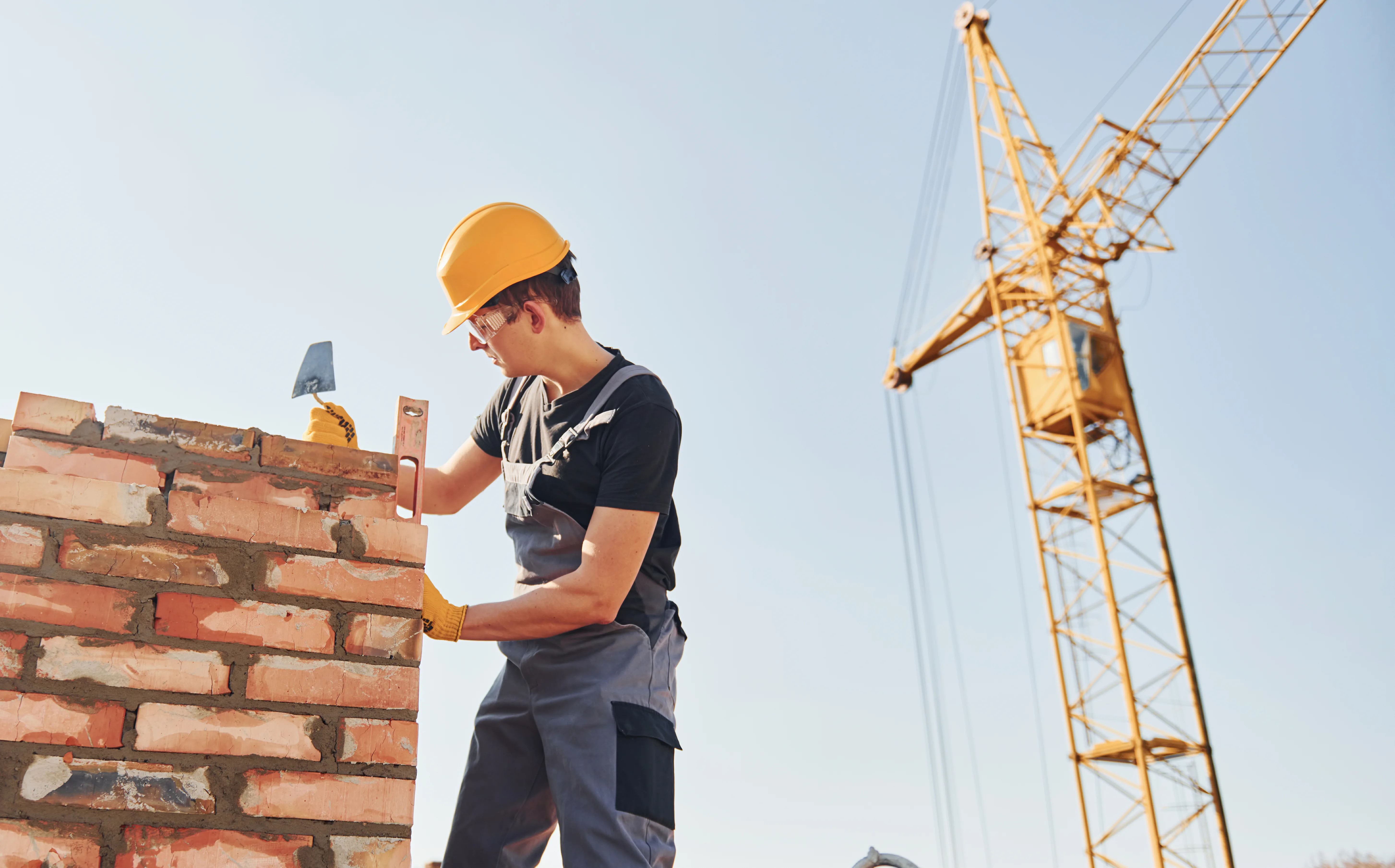 Operaio in cantiere che costruisce un muro